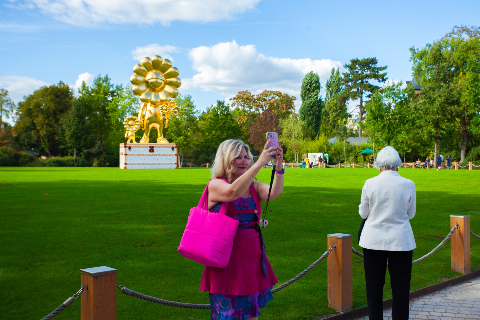 Sarah in hot pink with a Murakami sculpture in a Paris garden