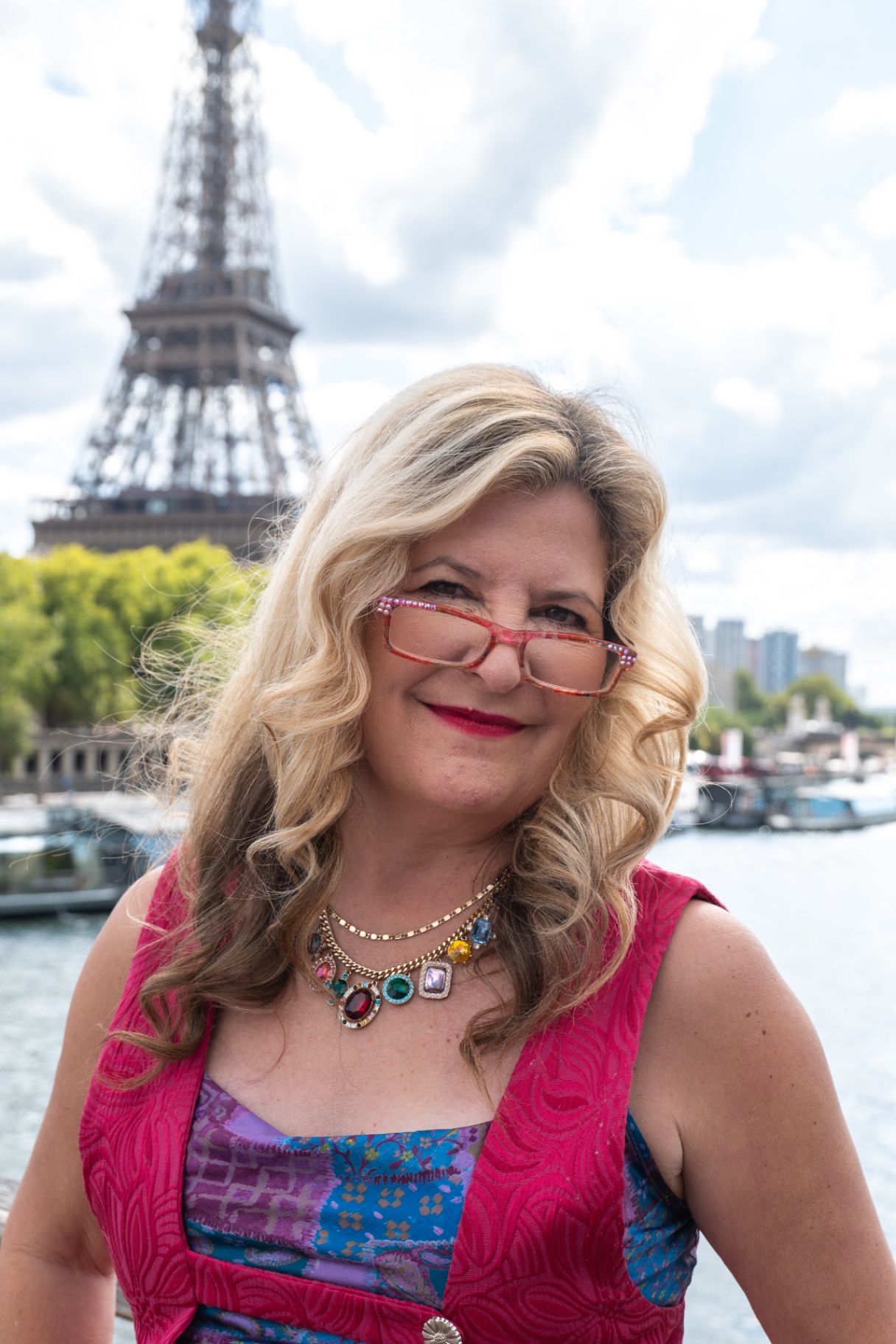 Portrait of Sarah in a jewel-tone dress on the Seine with the Eiffel Tower behind her